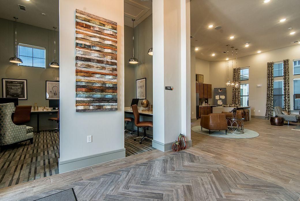 Spacious on-site community lounge with workstations, seating areas, and artwork.