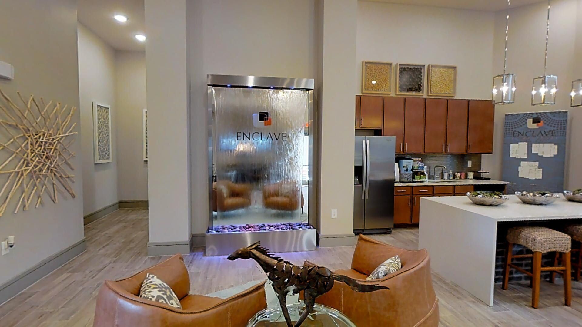 Lounge area in a multifamily property with kitchenette, island seating, and modern decor.