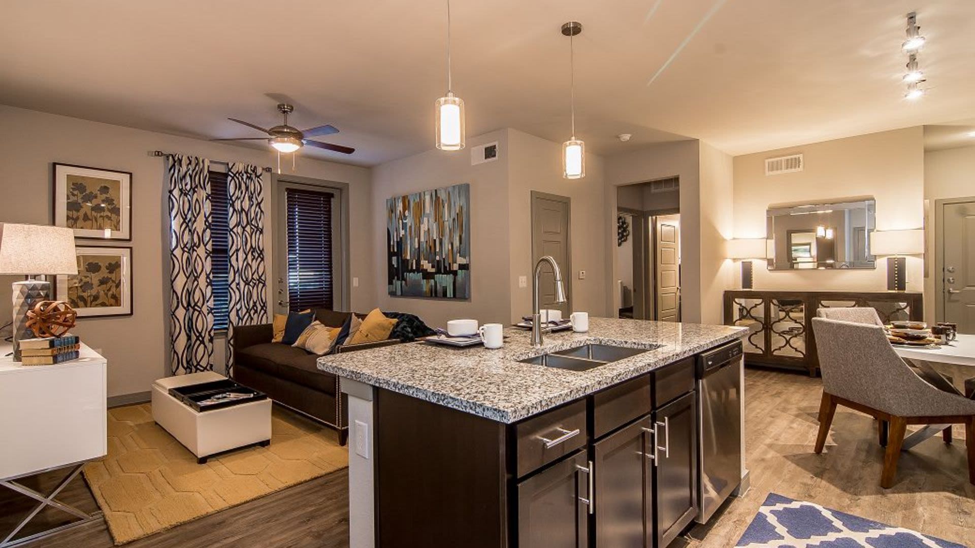Open-concept kitchen and living area with granite island and stainless appliances.