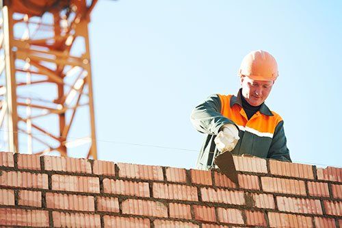 mason laying bricks