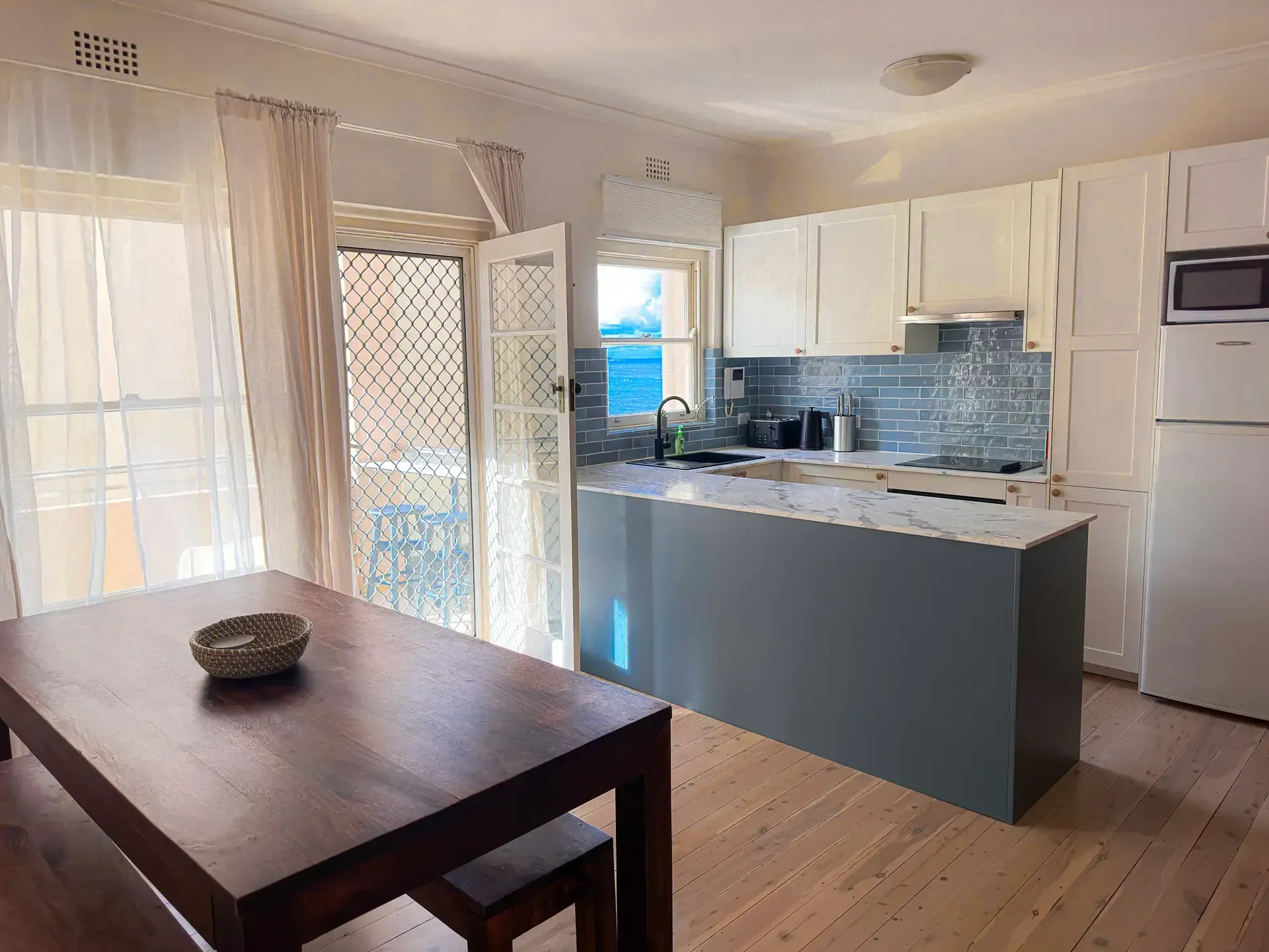 A kitchen with a table and chairs and a refrigerator.