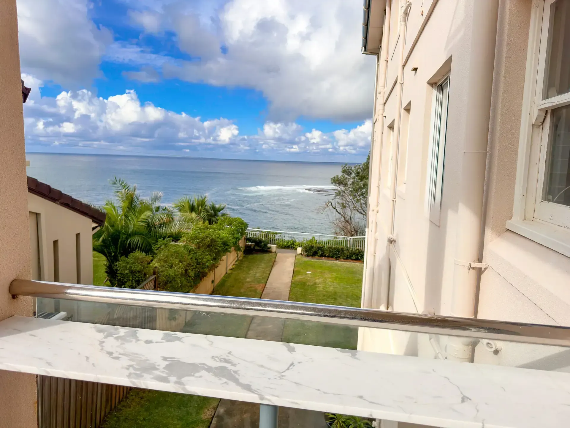 A view of the ocean from a balcony of a building.