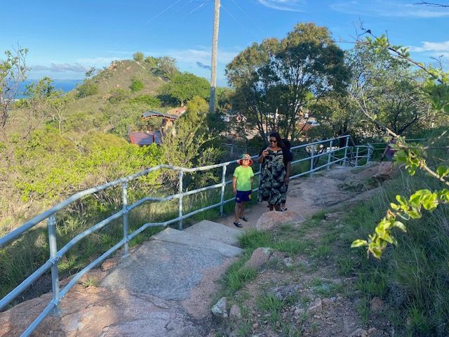A woman and a child are walking down a path next to a railing.