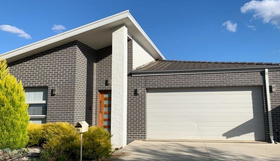A brick house with a white garage door and a mailbox in front of it.