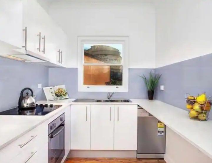 A kitchen with white cabinets and stainless steel appliances