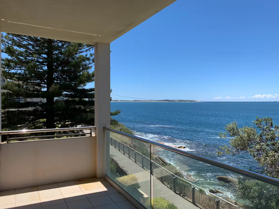 A balcony overlooking the ocean on a sunny day