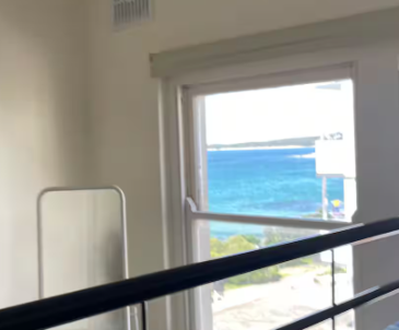 There is a large window with a view of the ocean.