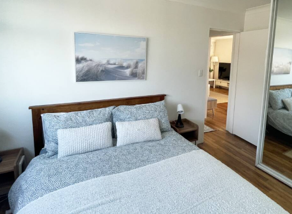 A bedroom with a large bed and a large mirror
