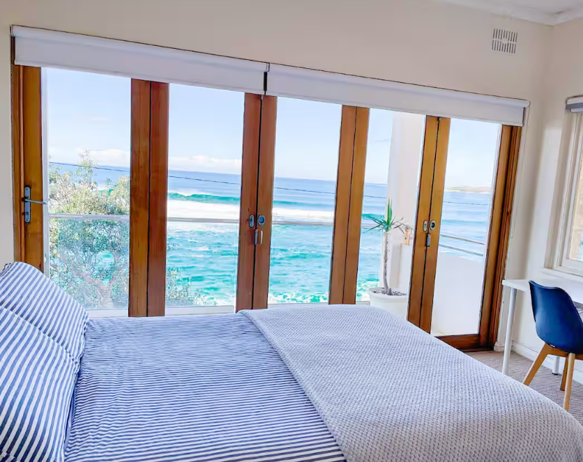 A bedroom with a large bed and a view of the ocean