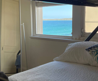 A bedroom with a bunk bed and a window overlooking the ocean