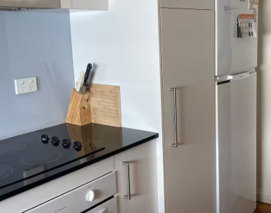 A kitchen with a stove top oven and a refrigerator