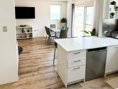A kitchen with white cabinets and a stainless steel dishwasher