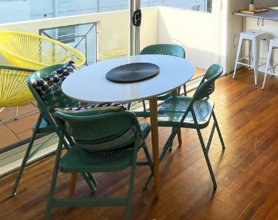 A table and chairs are sitting on a wooden floor in a room.
