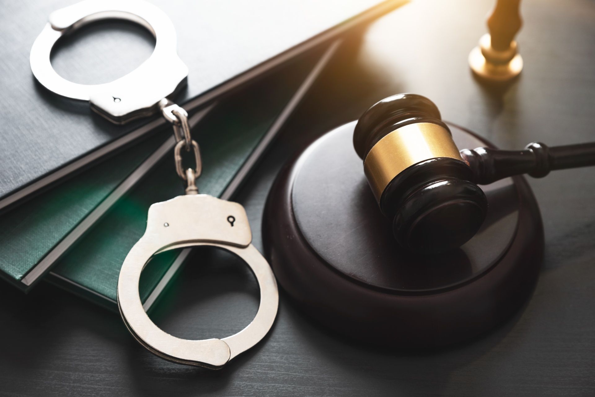 A pair of handcuffs and a judge 's gavel on a table.