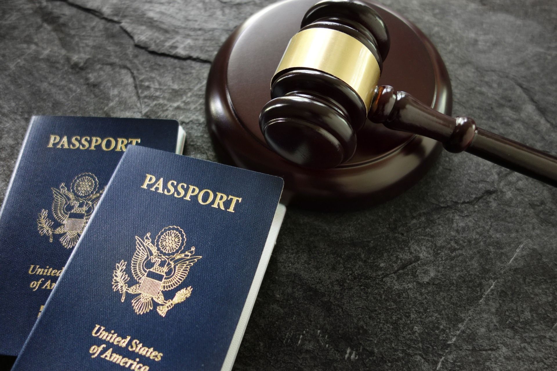 Two passports and a judge 's gavel on a table