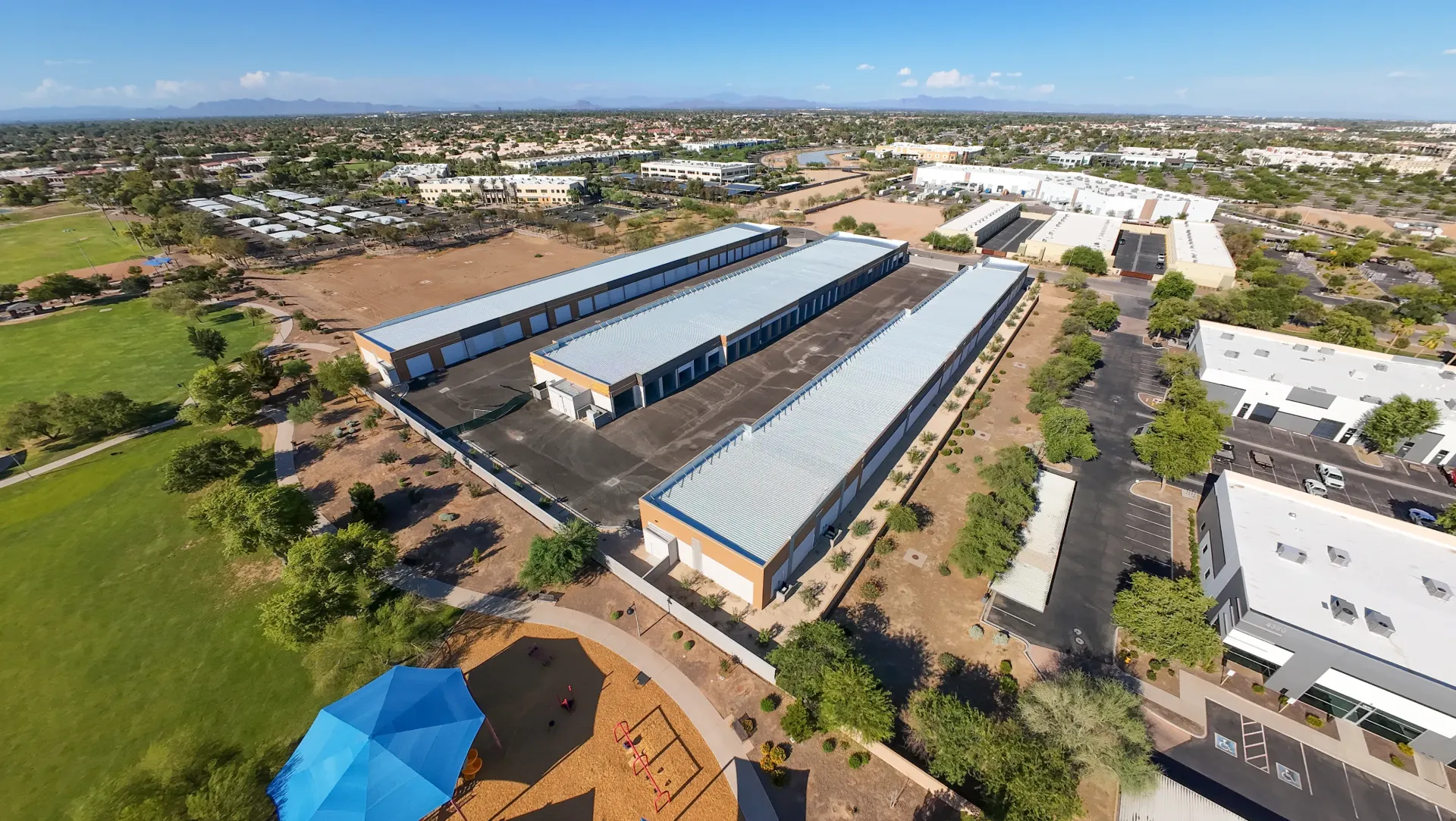 An aerial view of a large building with a blue umbrella in the foreground.