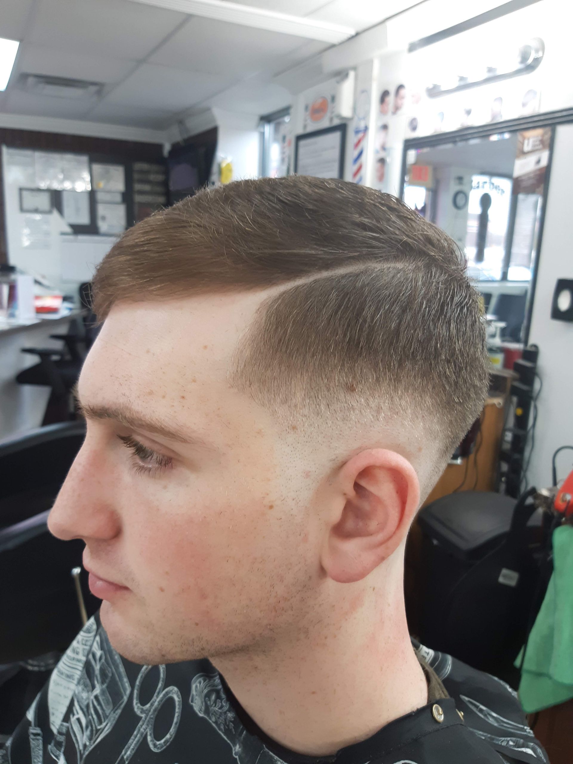A man is getting his hair cut at a barber shop