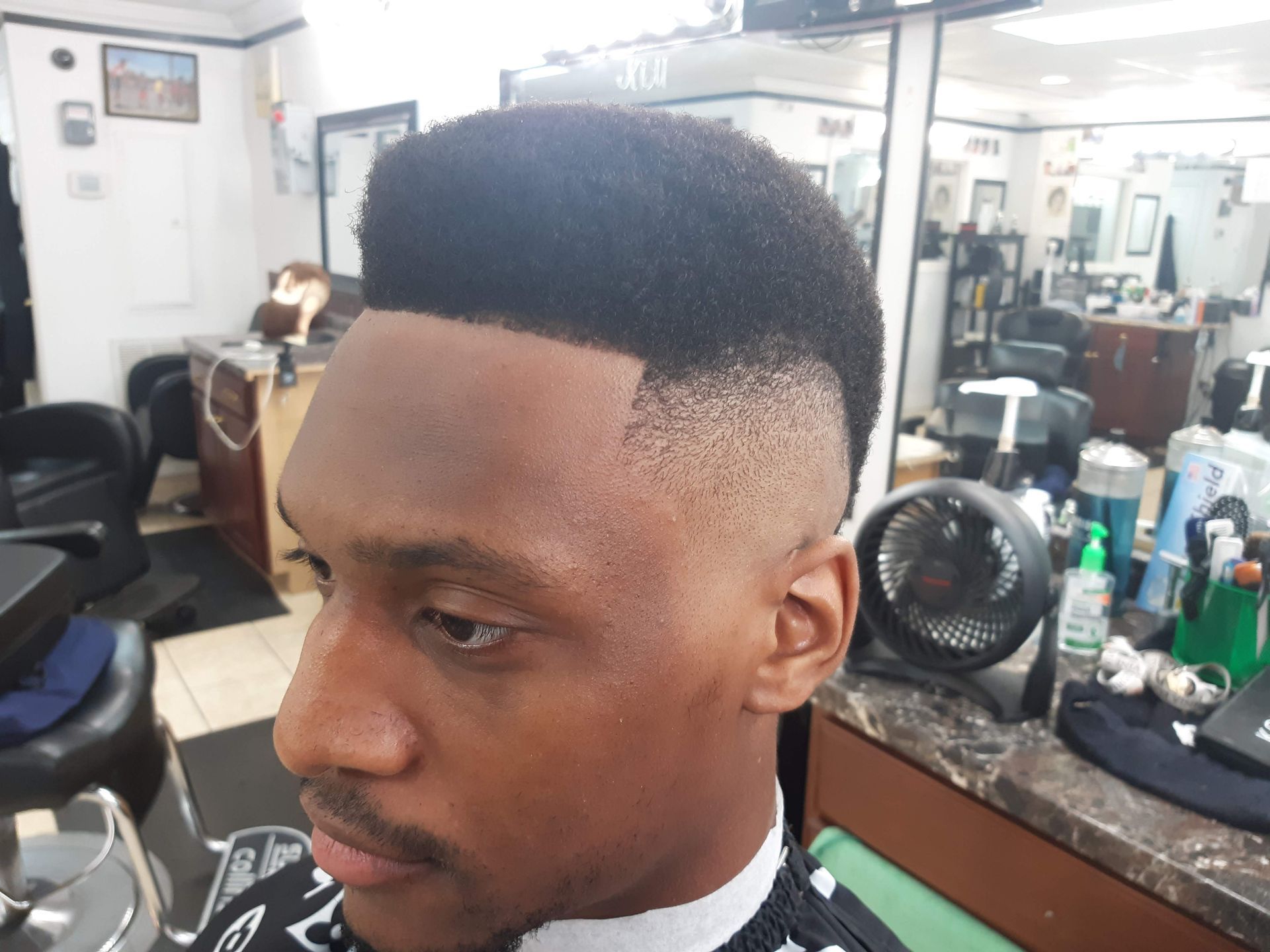 A man is getting his hair cut at a barber shop