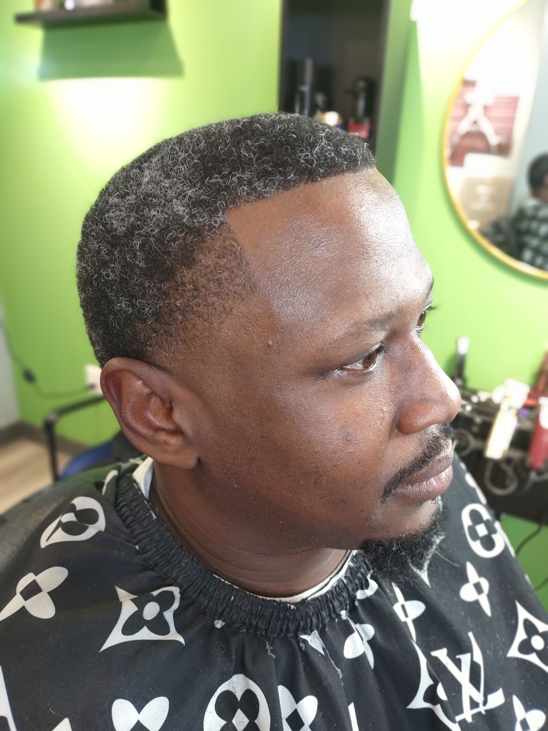 A man is getting his hair cut at a barber shop