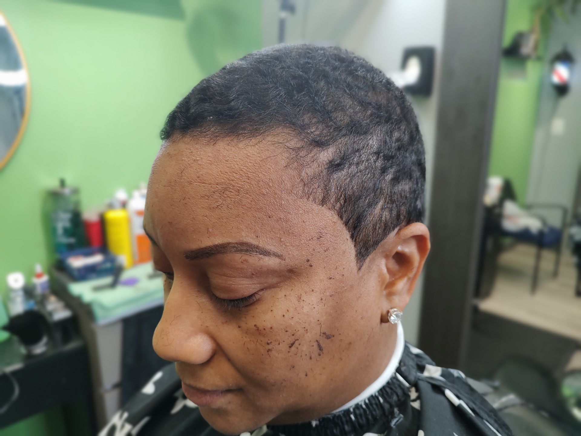 A woman is getting her hair cut in a salon.