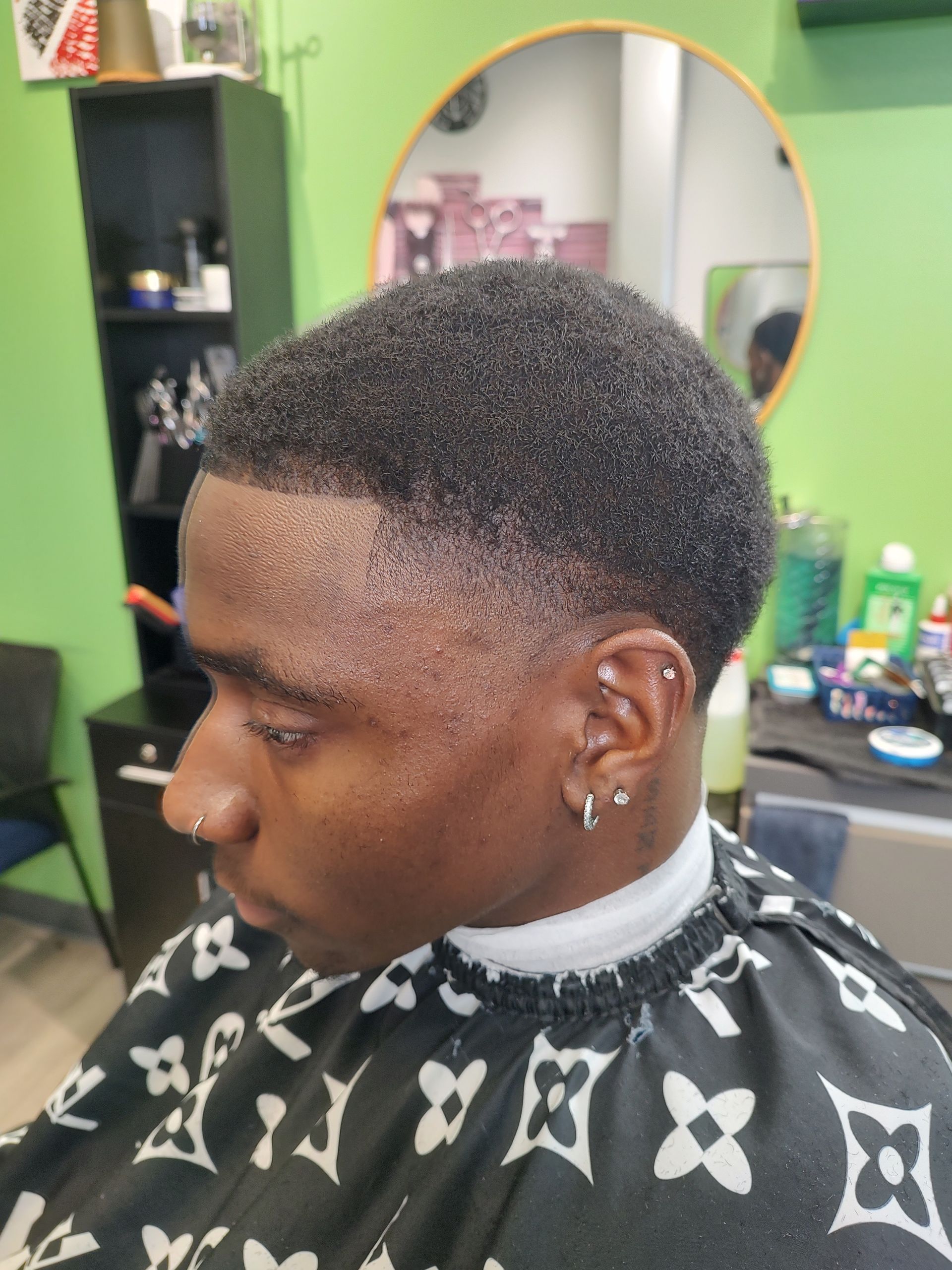 A man is getting his hair cut at a barber shop