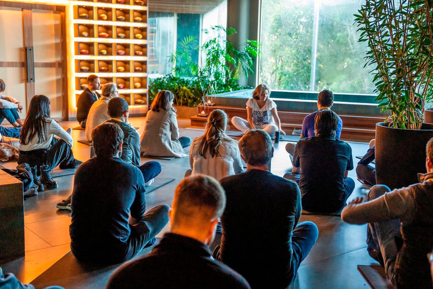 Um grupo de pessoas está sentado no chão em círculo.