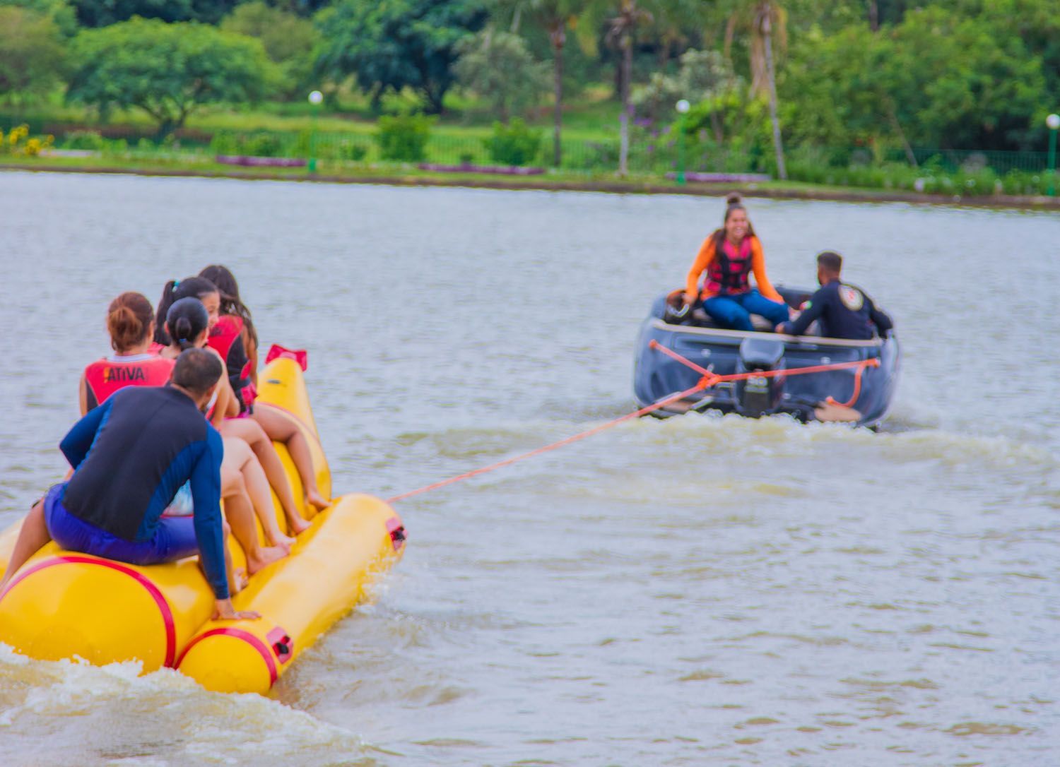 Um grupo de pessoas está andando de banana boat em um lago.