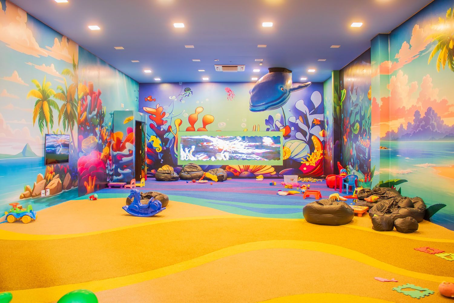 Uma grande sala cheia de brinquedos e pinturas nas paredes.