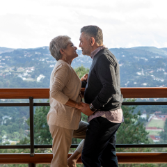 Um homem e uma mulher estão parados um ao lado do outro em uma sacada.