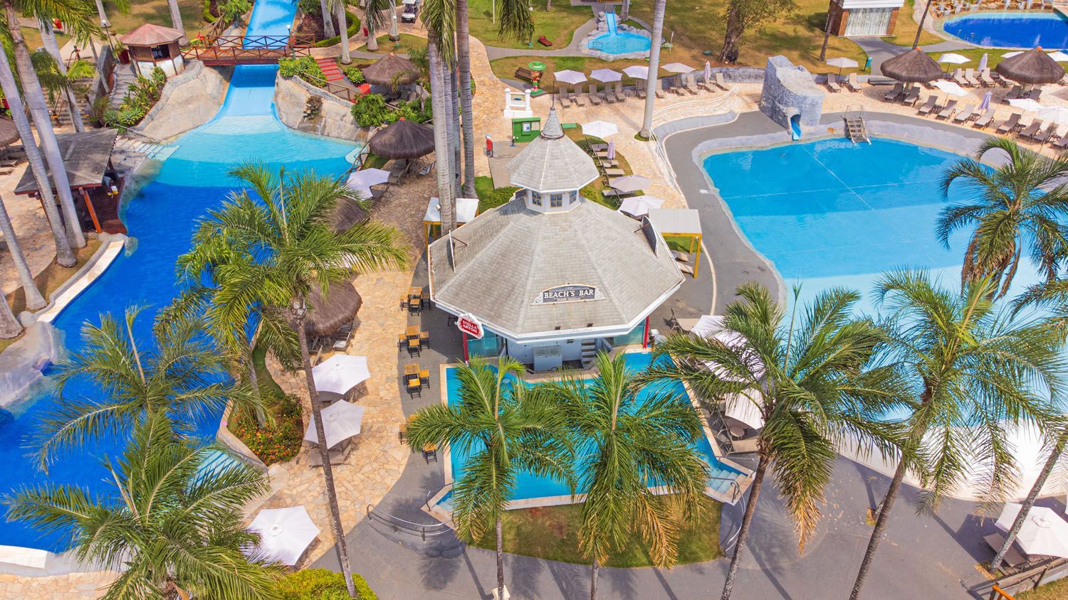 Uma vista aérea de uma grande piscina cercada por palmeiras.