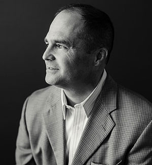 A black and white photo of a man in a suit and tie.