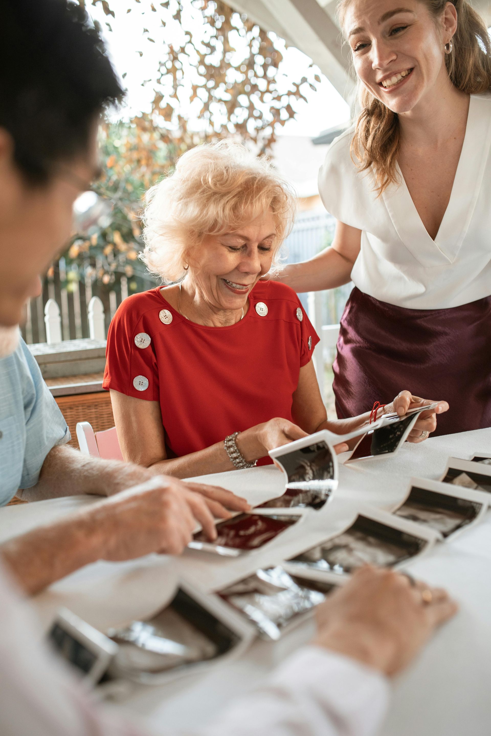A group of people are sitting at a table looking at pictures.