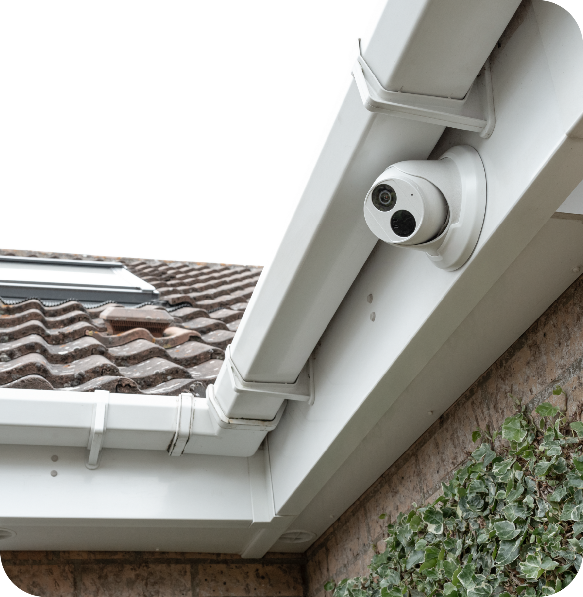 A security camera is mounted on the roof of a house.