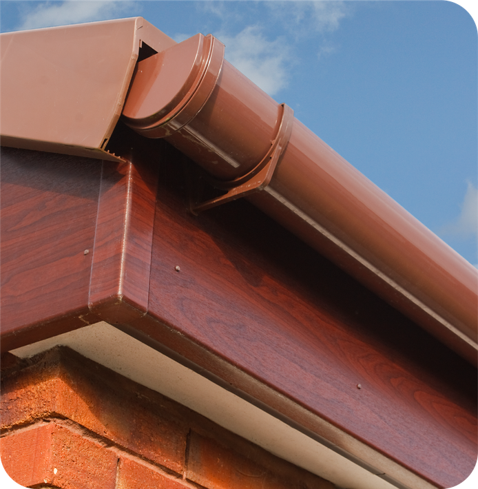 A close up of a brown gutter on a brick building