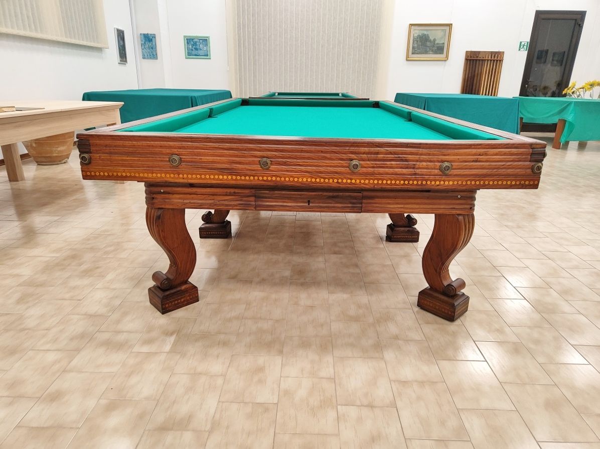 Biliardo del ‘700 autentico ed integro 
in ogni sua parte, finemente restaurato secondo i dettami dell’epoca, lucidato a spirito e finitura a cera.
Il piano di gioco è in legno, anch’esso spianato con pialle manuali e restaurato.
Il biliardo è completamente realizzato in massello di noce e le parti esterne sono arricchite da numerosi intarsi e sottili filetti di acero.
Campo gioco 2,90x1,45 – pezzo unico