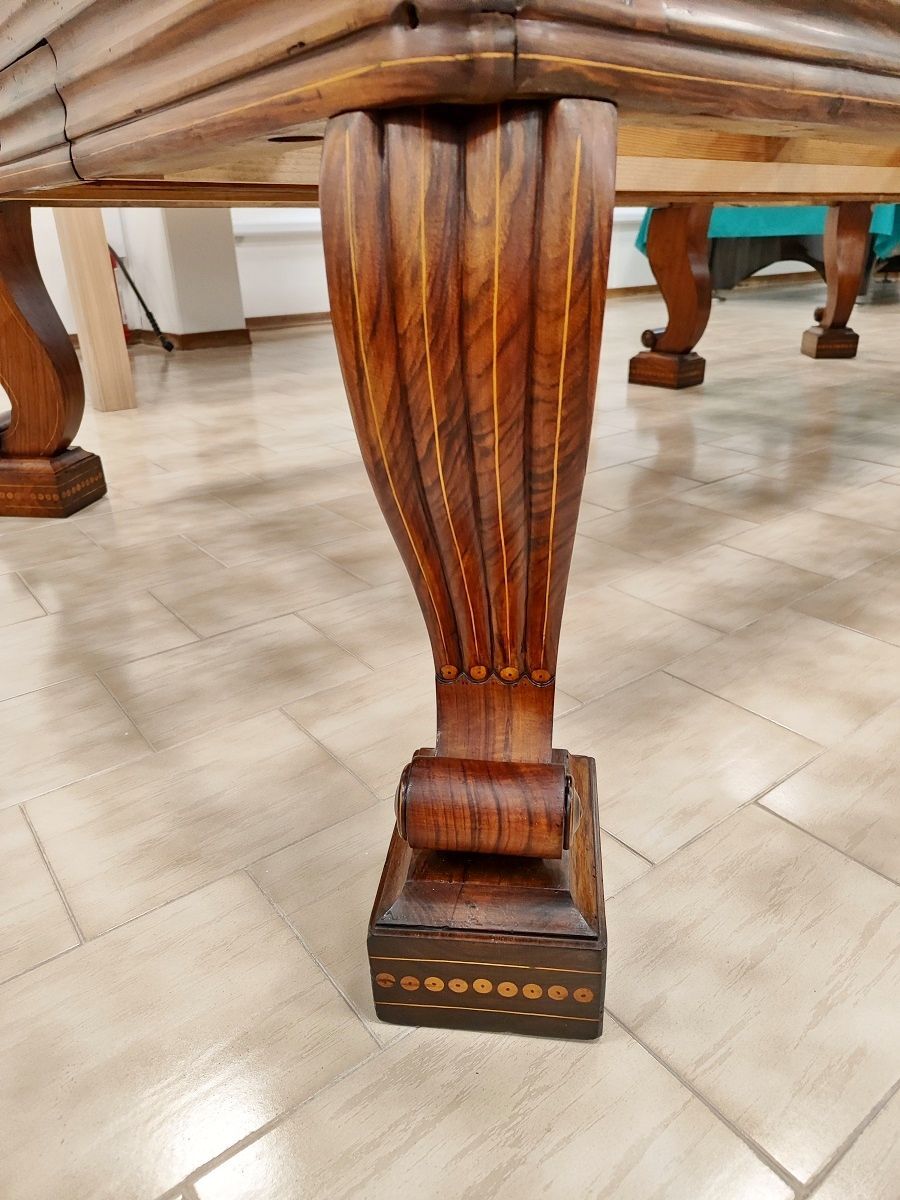 Biliardo del ‘700 autentico ed integro 
in ogni sua parte, finemente restaurato secondo i dettami dell’epoca, lucidato a spirito e finitura a cera.
Il piano di gioco è in legno, anch’esso spianato con pialle manuali e restaurato.
Il biliardo è completamente realizzato in massello di noce e le parti esterne sono arricchite da numerosi intarsi e sottili filetti di acero.
Campo gioco 2,90x1,45 – pezzo unico