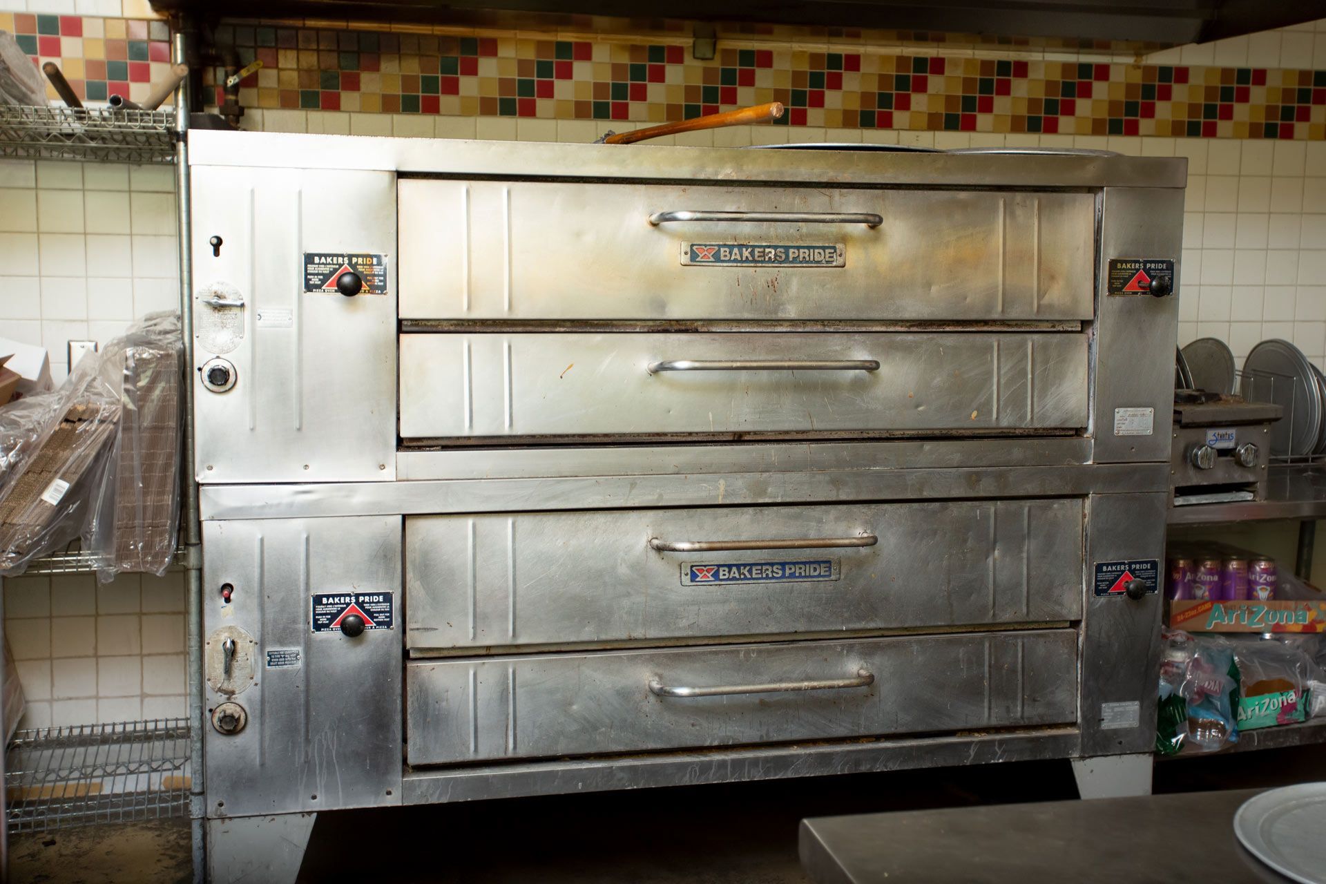 Large industrial pizza oven with three oven compartments. Stainless steel. In a commercial kitchen.