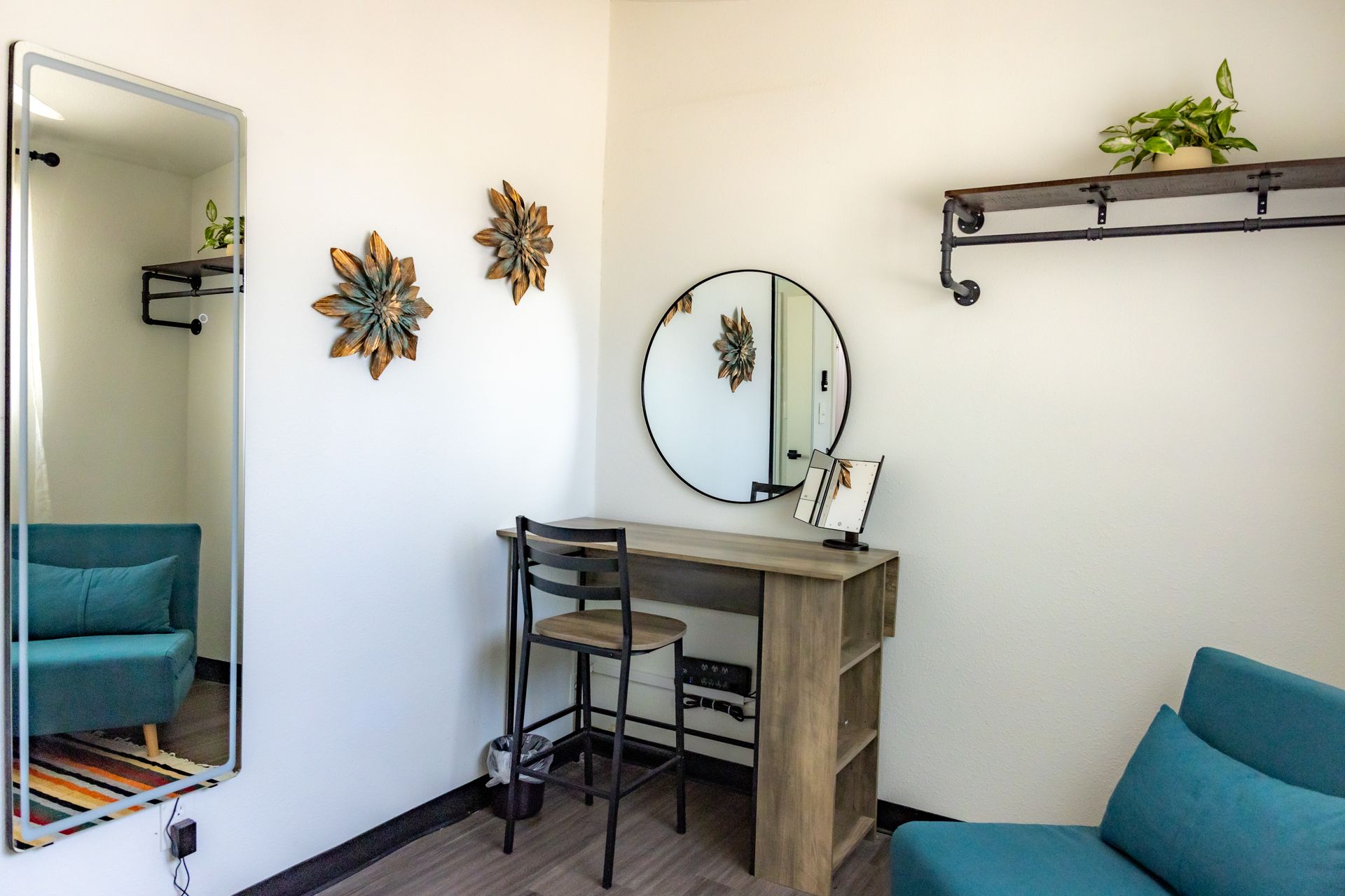 Living room at MAHA ATX for guests featuring a couch, desk, and wall-mounted mirror
