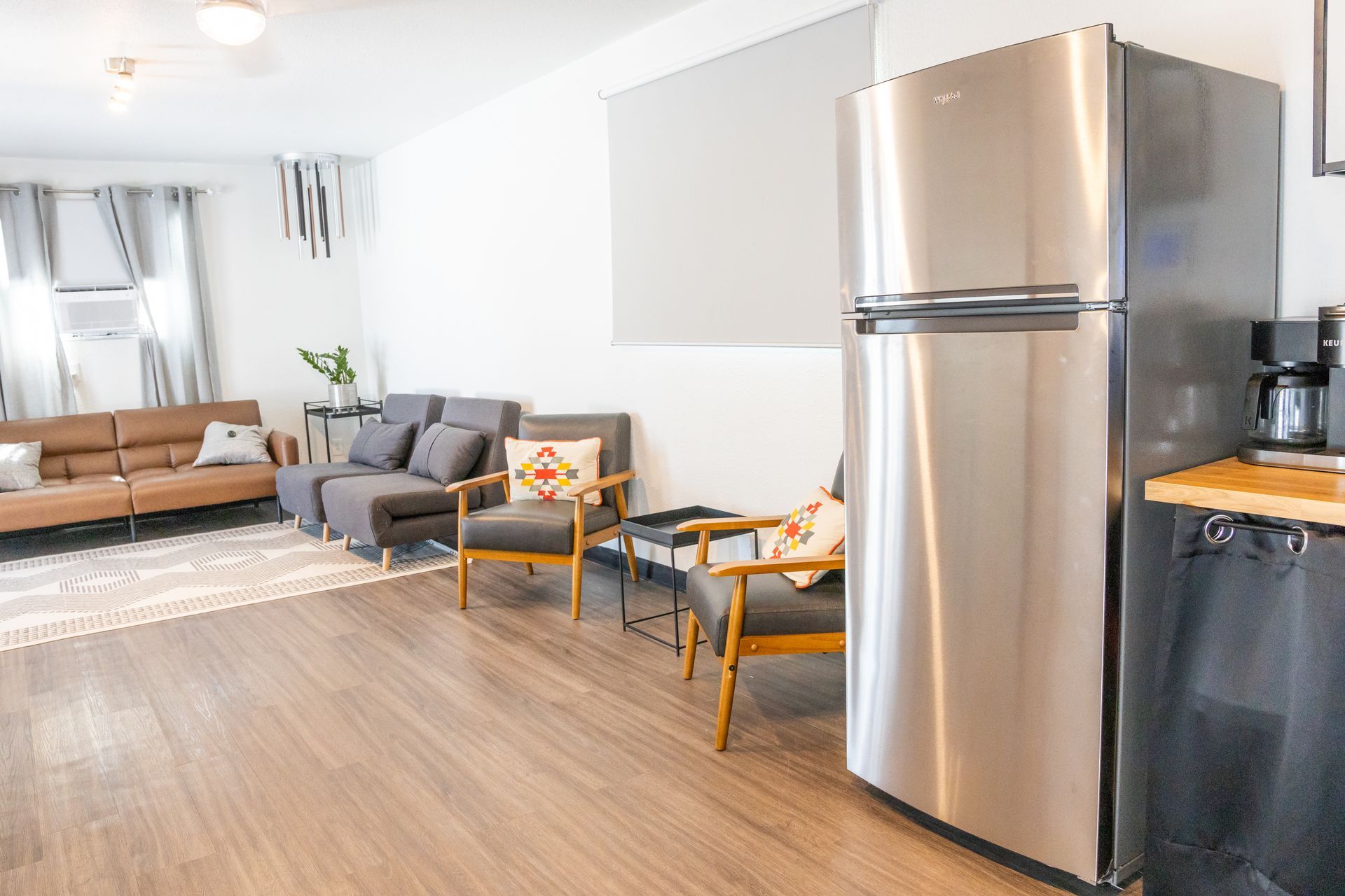 Additional room at MAHA ATX in Austin with couches, chairs, tables, and a refrigerator