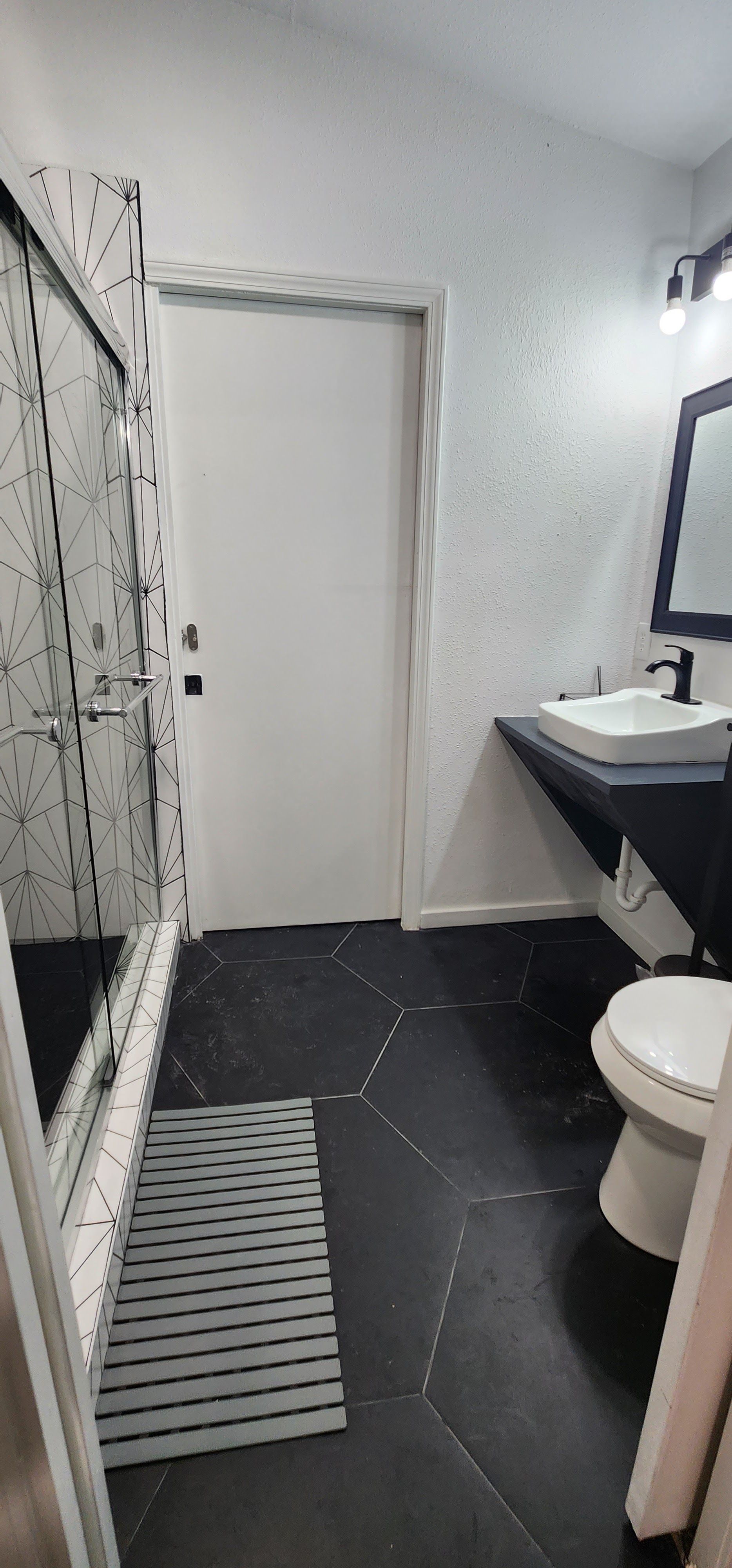 MAHA ATX bathroom with a toilet, sink, and shower stall in Austin, Texas