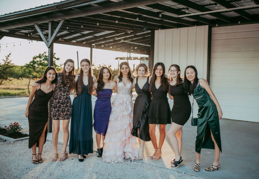 A group of women standing next to each other smiling for a photo outside an event venue in Austin, TX