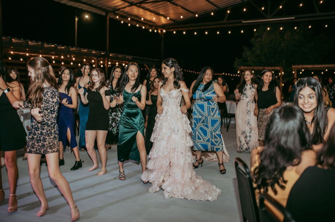 A group of women standing next to each other and dancing on an event in Austin
