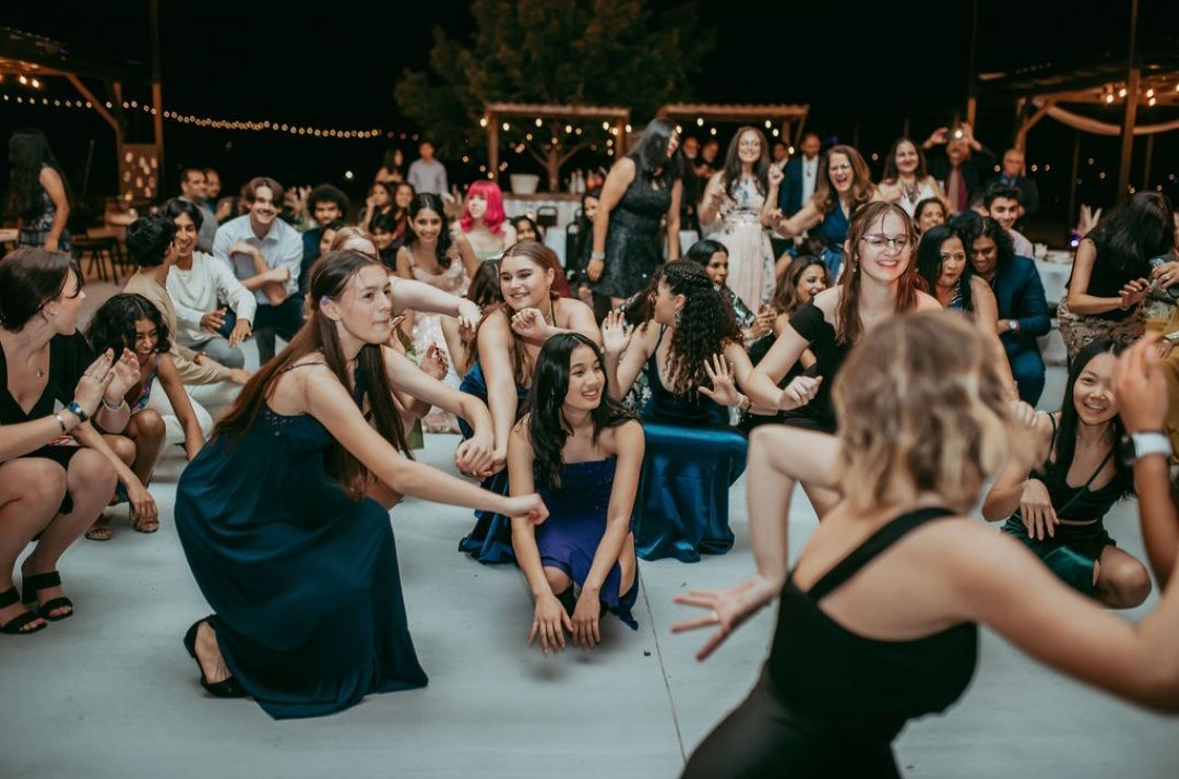 A group of event attendees are sitting on the ground during a event celebration in Austin, TX
