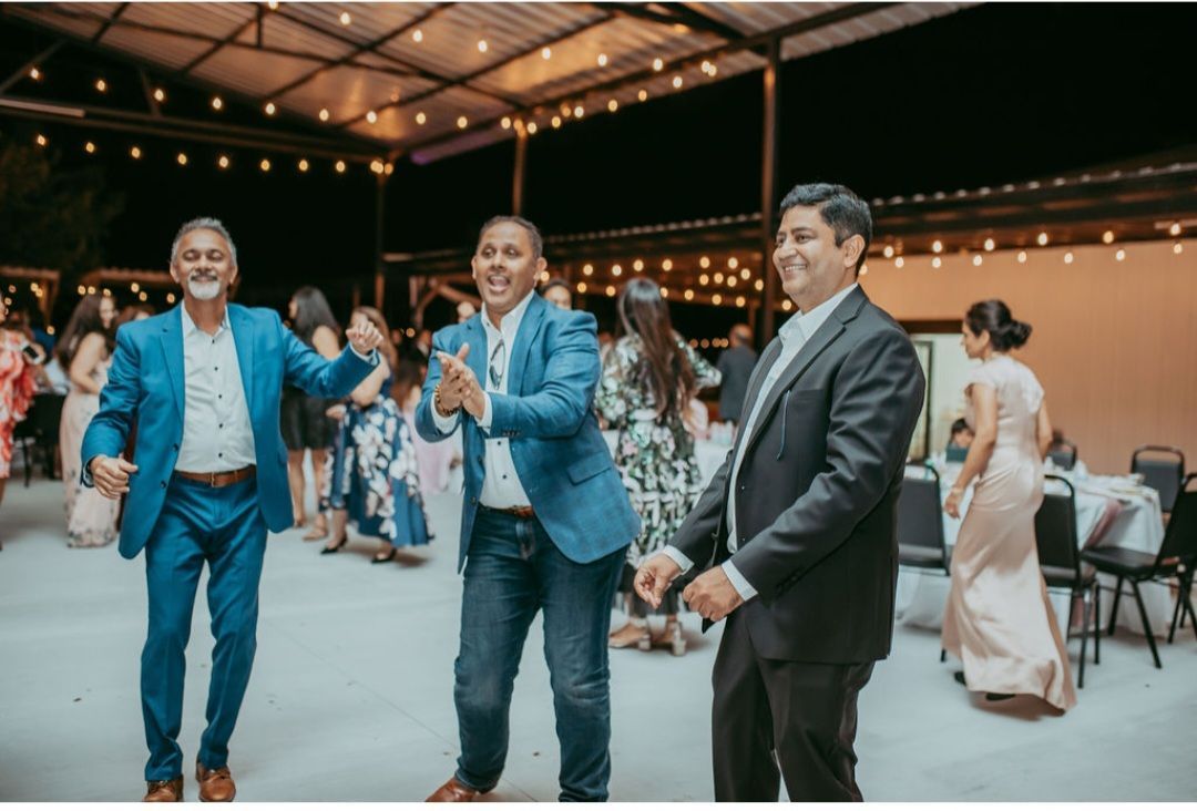 A couple of men standing next to each other on a dance floor during an event