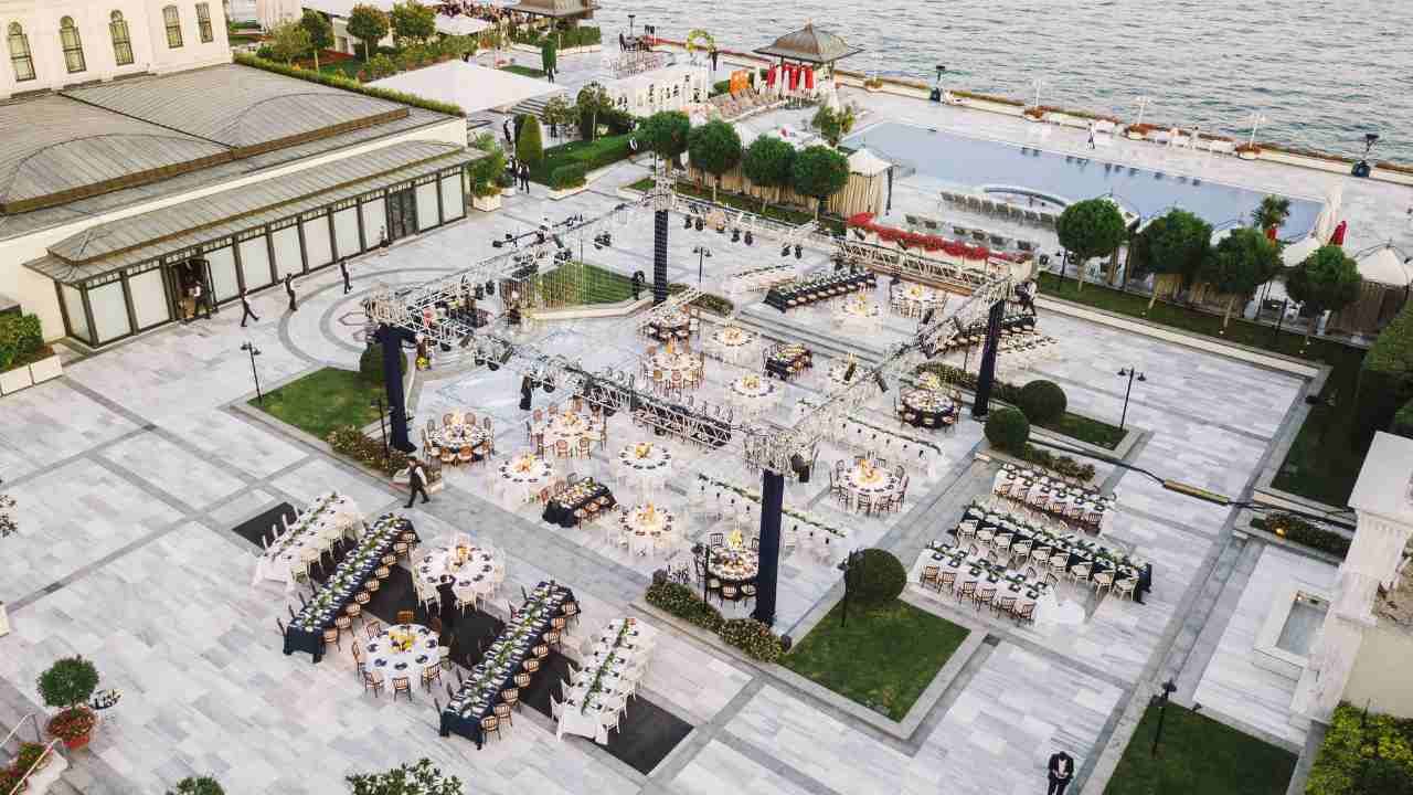 Overhead shot of a beach wedding reception setup with tables and chairs.