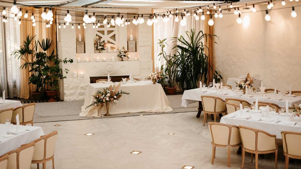 A beautifully arranged wedding reception featuring elegant white tables and chairs.