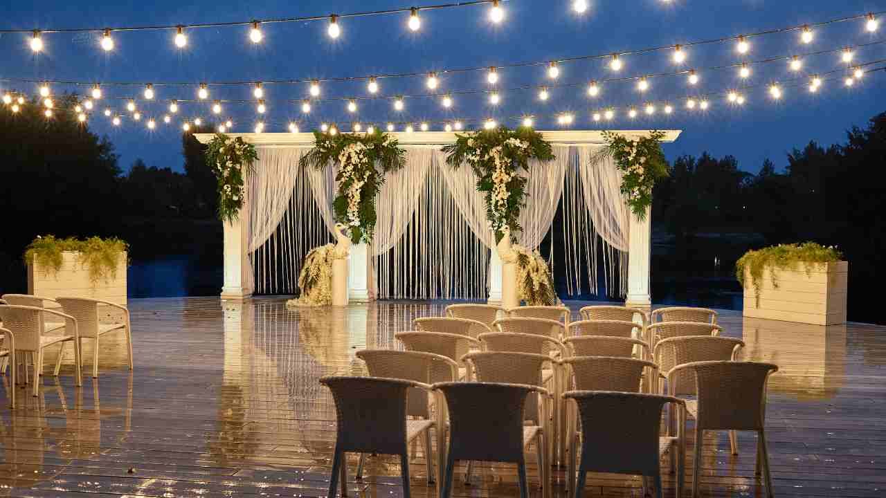 An outdoor wedding ceremony adorned with string lights.