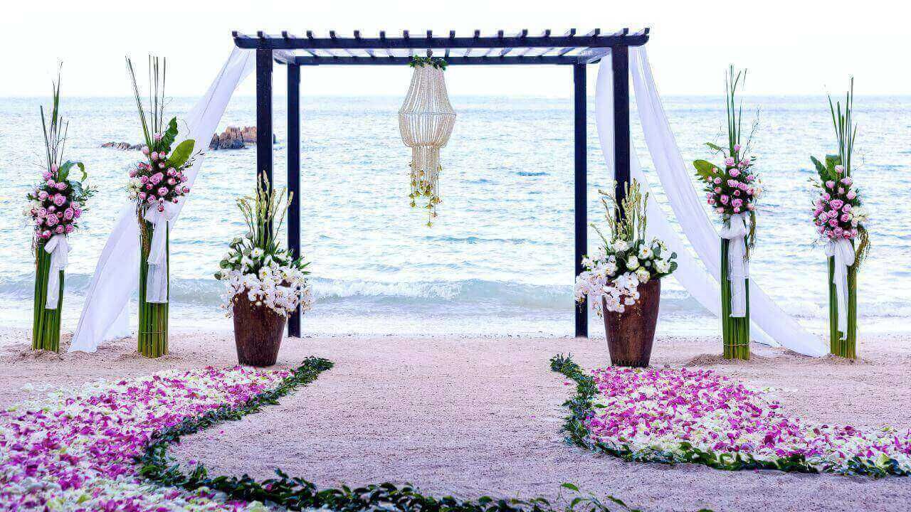 A beautiful beach wedding ceremony adorned with flowers.