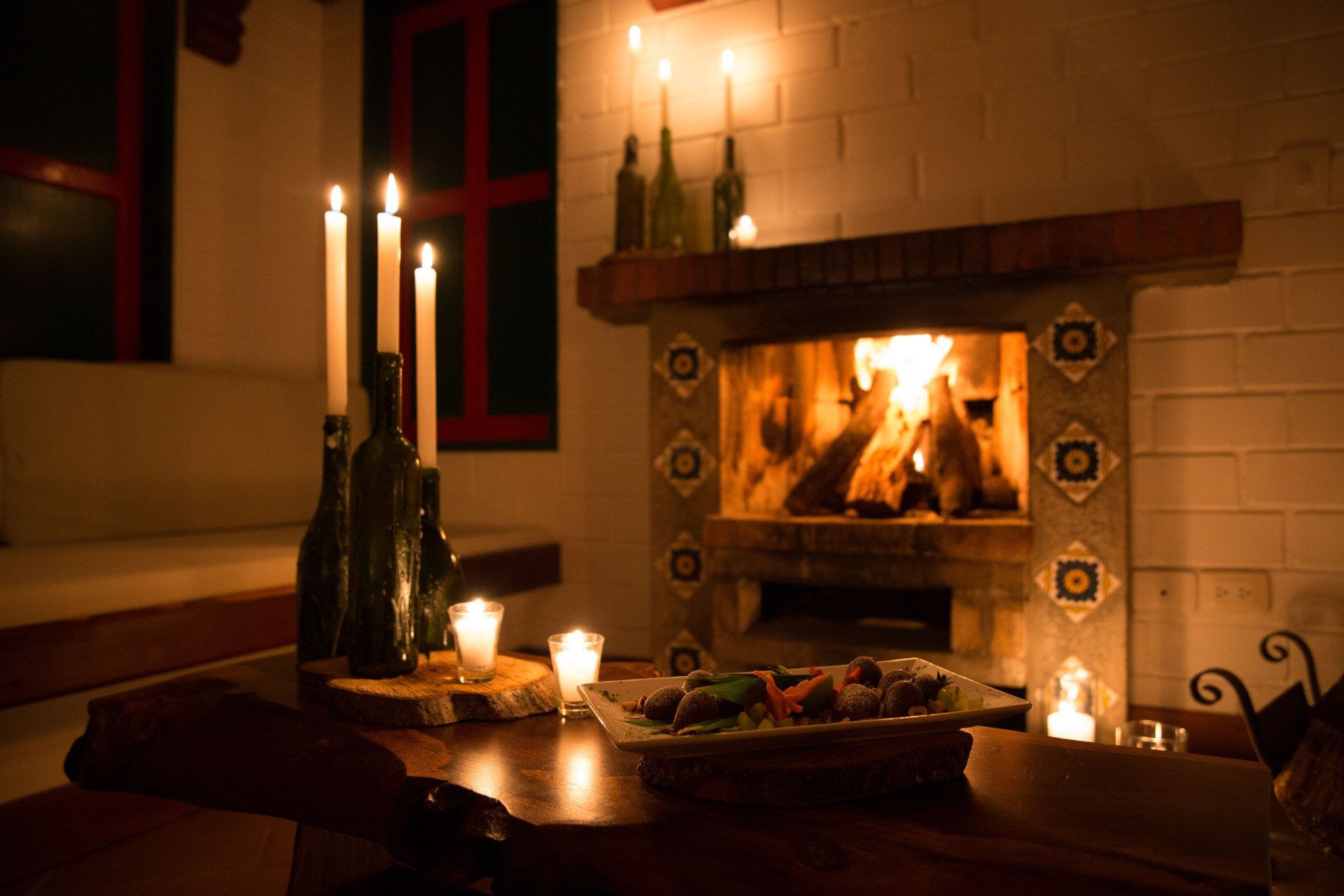 Chimenea encendida con velas y ambiente íntimo en Hotel Termales El Otoño, plan romántico cerca a Manizales.