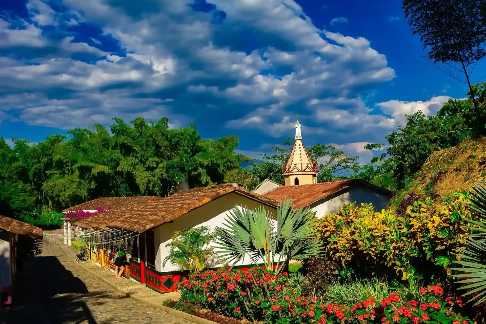 Arquitectura tradicional del Eje Cafetero, con casa típica, jardines coloridos en un entorno natural ideal para visitantes de los termales.